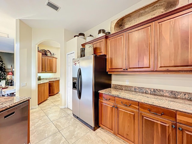 kitchen featuring light tile patterned flooring, light stone countertops, and appliances with stainless steel finishes