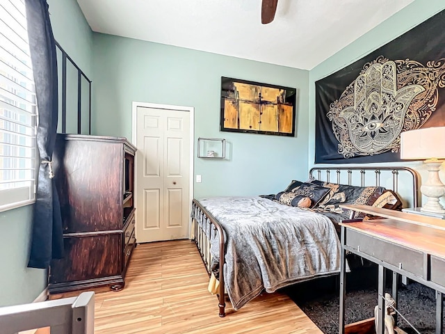 bedroom featuring ceiling fan, a closet, and light hardwood / wood-style flooring