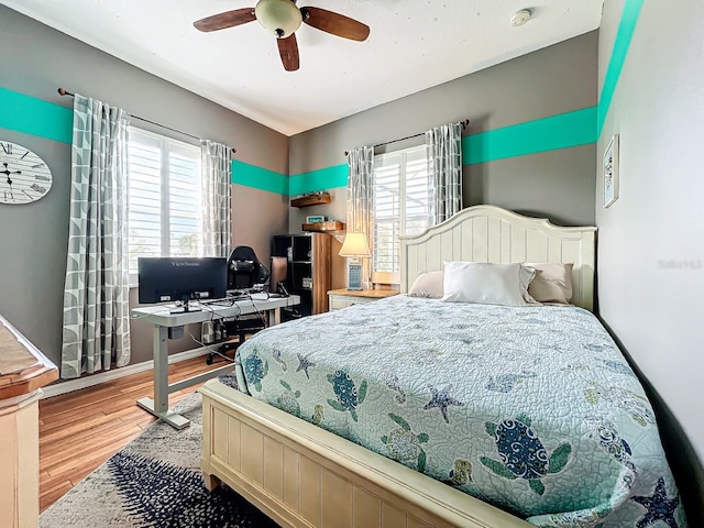 bedroom with wood-type flooring, multiple windows, and ceiling fan