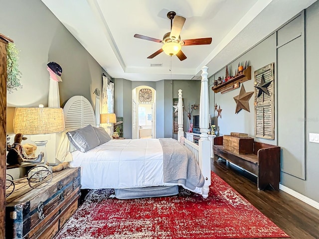 bedroom featuring dark hardwood / wood-style floors, ceiling fan, and ornate columns