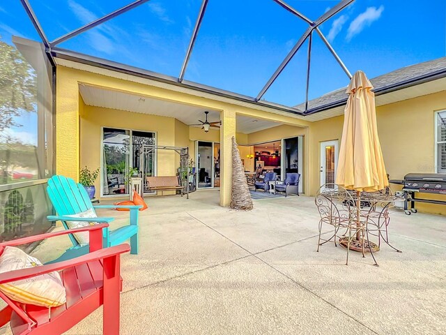 back of property with a lanai, ceiling fan, and a patio