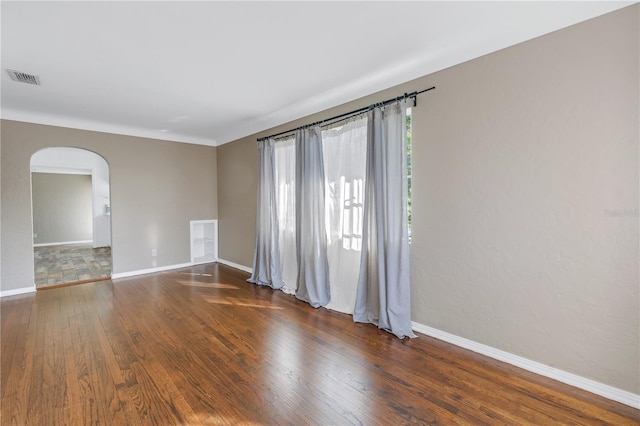 spare room with dark wood-type flooring