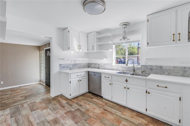 kitchen featuring stainless steel dishwasher, sink, decorative light fixtures, white cabinets, and light hardwood / wood-style floors