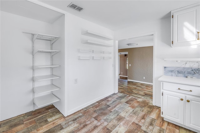 interior space with white cabinetry and hardwood / wood-style flooring