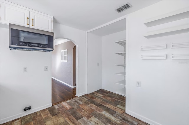 interior space featuring white cabinets and dark wood-type flooring