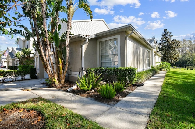 1687 Starling Dr, Tarpon Springs, FL 34689 - view of side of home with stucco siding and a yard