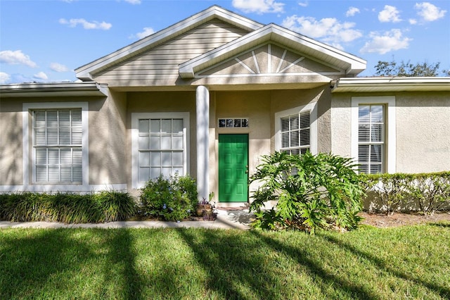 view of exterior entry featuring a yard