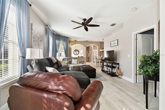 living room featuring a textured ceiling, light hardwood / wood-style floors, and ceiling fan