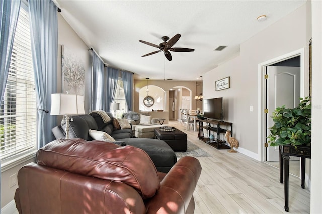 1687 Starling Dr, Tarpon Springs, FL 34689 - living area featuring arched walkways, ceiling fan, light wood finished floors, and baseboards