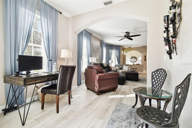 1687 Starling Dr, Tarpon Springs, FL 34689 - office area featuring arched walkways, a ceiling fan, light wood-type flooring, and baseboards