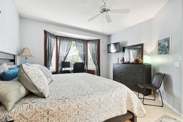 carpeted bedroom featuring ceiling fan and a textured ceiling