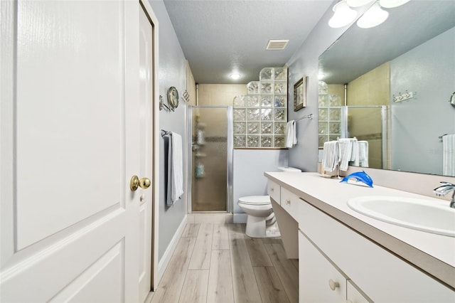 1687 Starling Dr, Tarpon Springs, FL 34689 - full bathroom with a stall shower, wood finished floors, vanity, and toilet