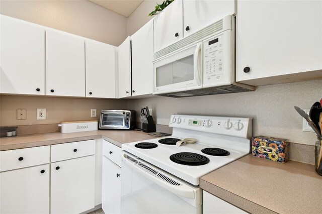 1687 Starling Dr, Tarpon Springs, FL 34689 - kitchen featuring white appliances, white cabinetry, and light countertops