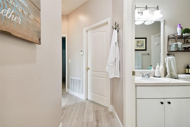 1687 Starling Dr, Tarpon Springs, FL 34689 - bathroom with wood finished floors, vanity, and baseboards