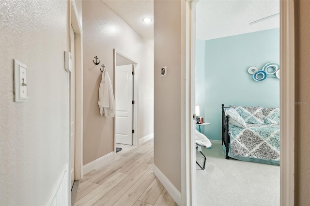 hallway with lofted ceiling and light hardwood / wood-style flooring