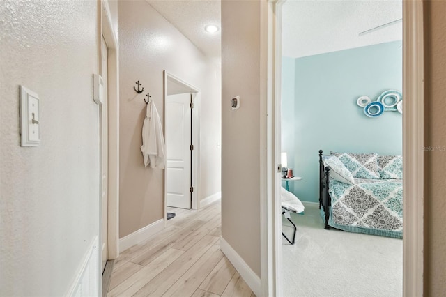 1687 Starling Dr, Tarpon Springs, FL 34689 - hallway with light wood-style flooring, baseboards, and a textured ceiling