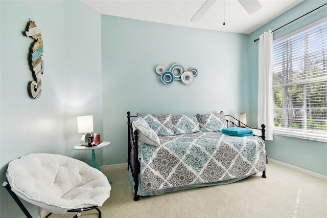 bedroom with carpet, a textured ceiling, and ceiling fan