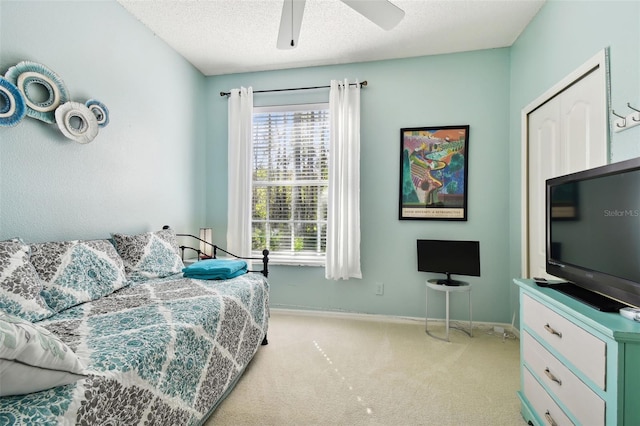 bedroom with multiple windows, ceiling fan, light colored carpet, and a textured ceiling