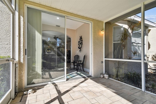 unfurnished sunroom with ceiling fan and plenty of natural light