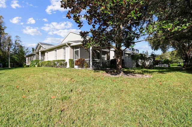 1687 Starling Dr, Tarpon Springs, FL 34689 - view of side of home featuring a lawn and a sunroom