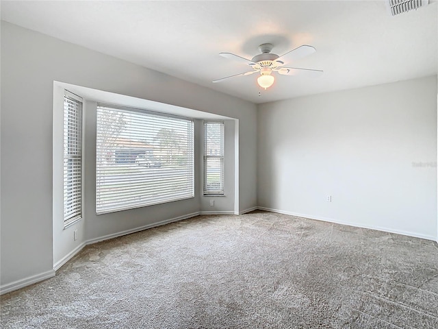 carpeted spare room featuring ceiling fan