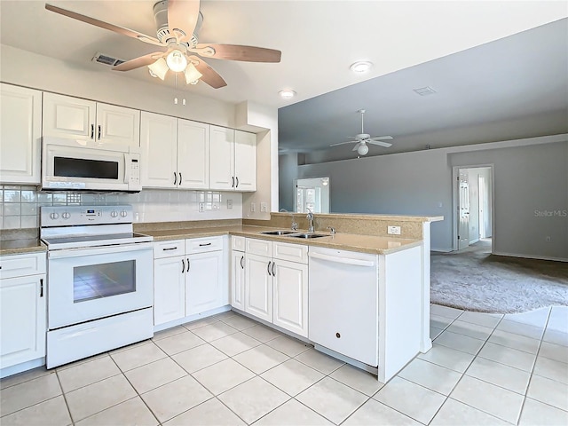 kitchen with white appliances, white cabinets, sink, light tile patterned flooring, and kitchen peninsula