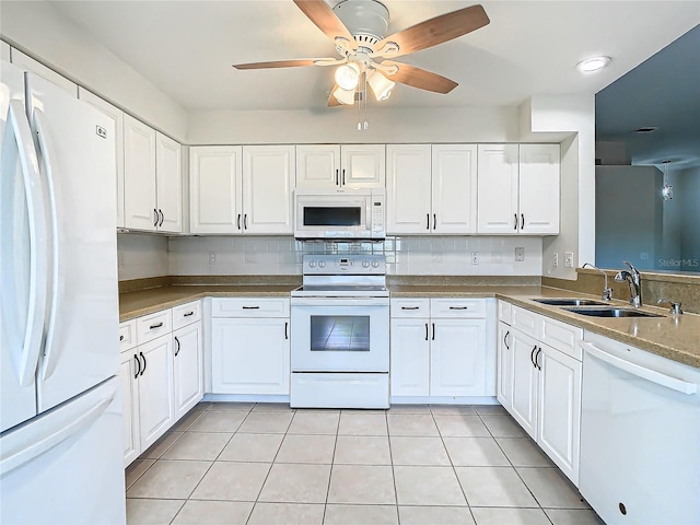 kitchen with white cabinets, light tile patterned floors, white appliances, and sink