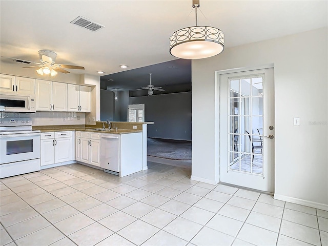 kitchen with white appliances, white cabinets, hanging light fixtures, light tile patterned floors, and kitchen peninsula