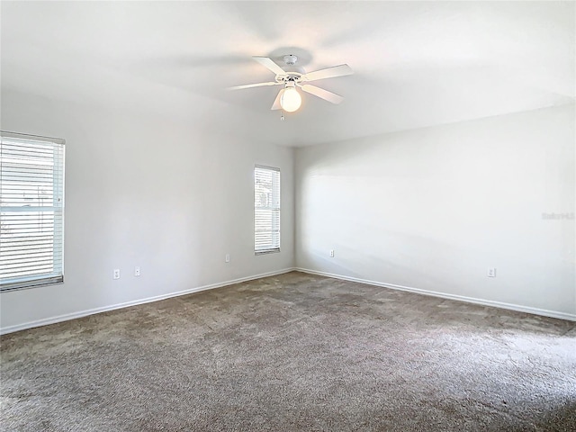 empty room featuring plenty of natural light, ceiling fan, and carpet floors