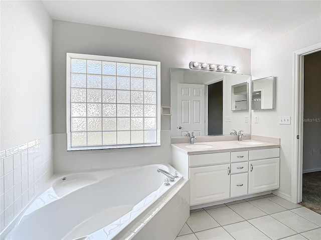 bathroom featuring vanity, tiled bath, and tile patterned floors