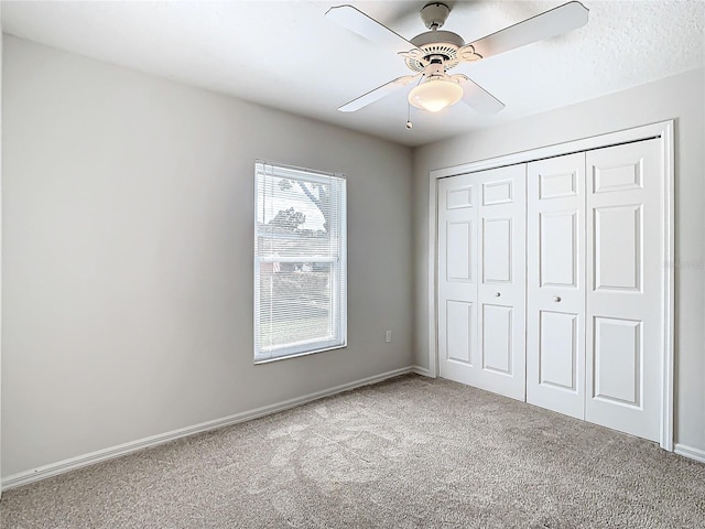 unfurnished bedroom featuring ceiling fan, light colored carpet, and a closet