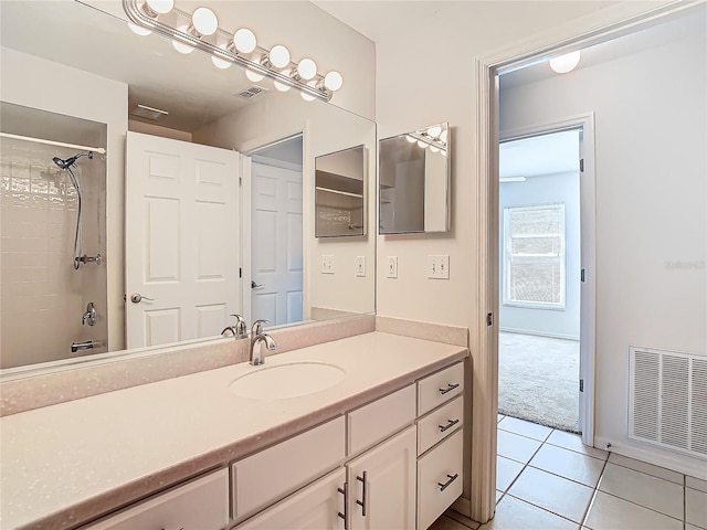 bathroom with tile patterned floors, vanity, and tiled shower / bath combo