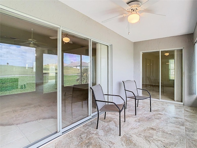 sunroom / solarium featuring ceiling fan