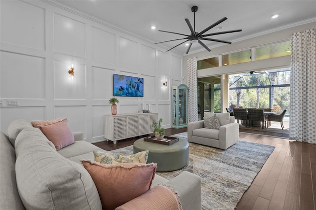 living room featuring dark hardwood / wood-style floors, ceiling fan, and crown molding