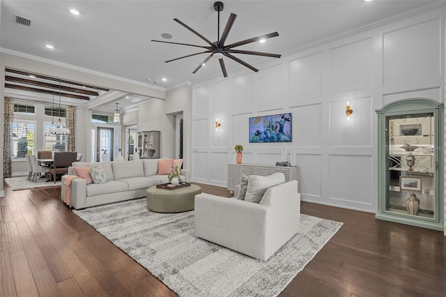 living room with crown molding, beamed ceiling, dark hardwood / wood-style floors, and an inviting chandelier