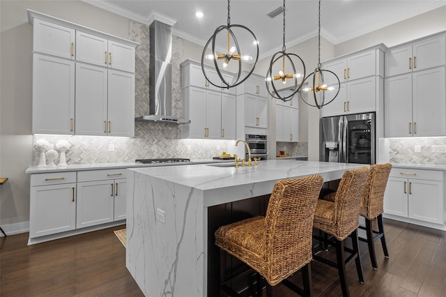 kitchen with a center island with sink, wall chimney exhaust hood, appliances with stainless steel finishes, dark hardwood / wood-style flooring, and white cabinetry