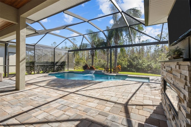 view of pool featuring a patio area, pool water feature, and glass enclosure