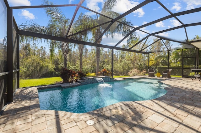 view of swimming pool with pool water feature, a patio area, and a lanai