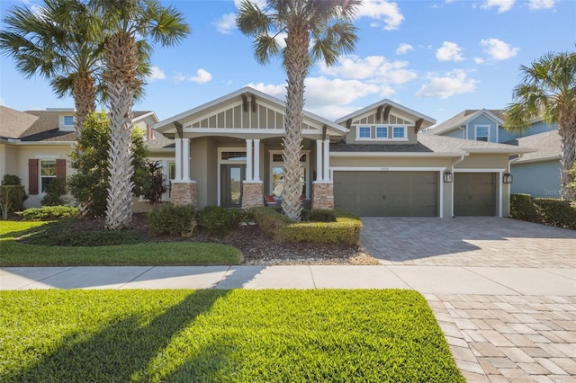 craftsman inspired home featuring covered porch, a garage, and a front lawn