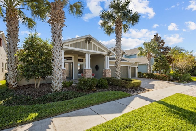 craftsman-style house featuring a porch, a garage, and a front lawn