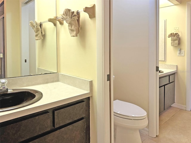 bathroom with tile patterned flooring, vanity, and toilet