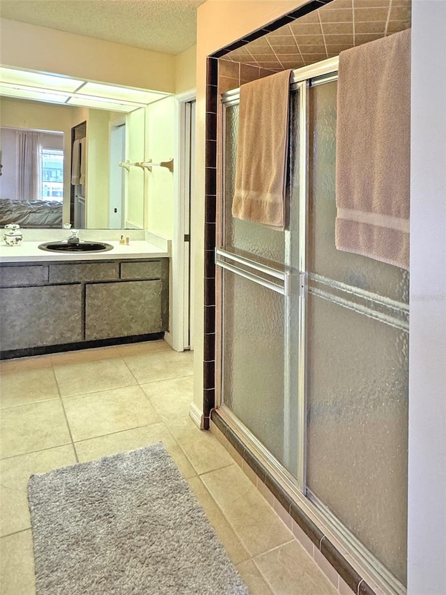 bathroom featuring tile patterned flooring, vanity, and an enclosed shower