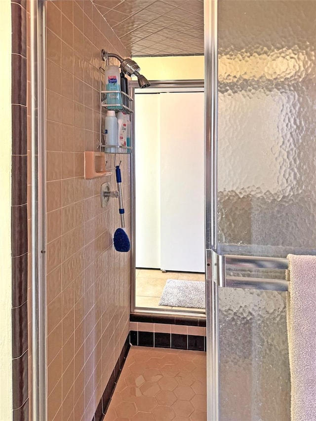 bathroom featuring tile patterned floors, a shower, and tile walls