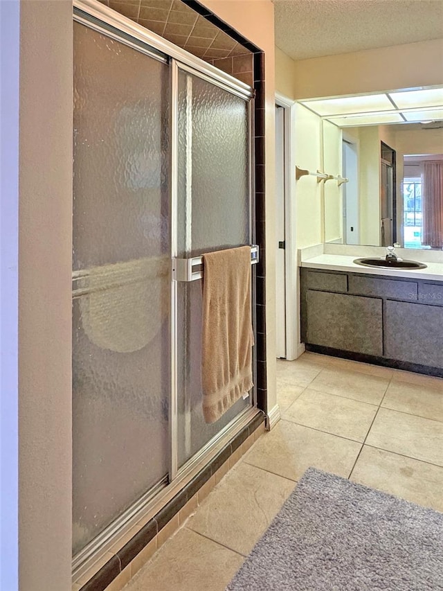 bathroom with tile patterned flooring, vanity, and a shower with door