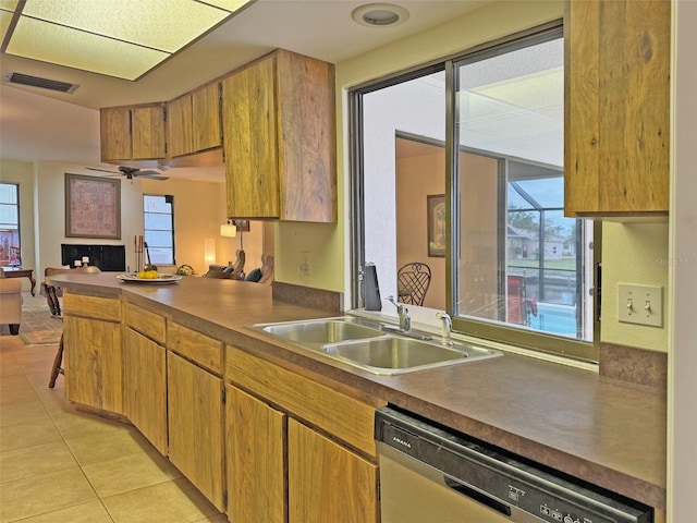 kitchen featuring kitchen peninsula, stainless steel dishwasher, ceiling fan, sink, and light tile patterned flooring