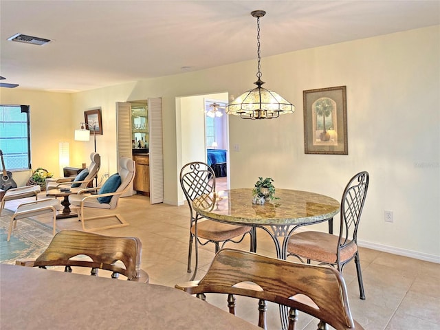 tiled dining room featuring an inviting chandelier