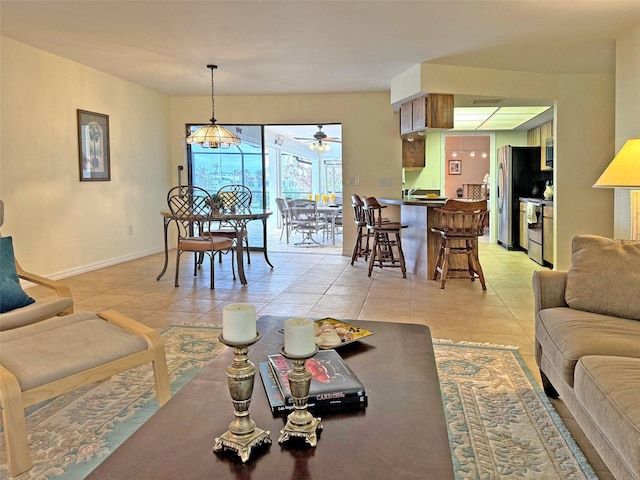 living room with light tile patterned floors and ceiling fan with notable chandelier