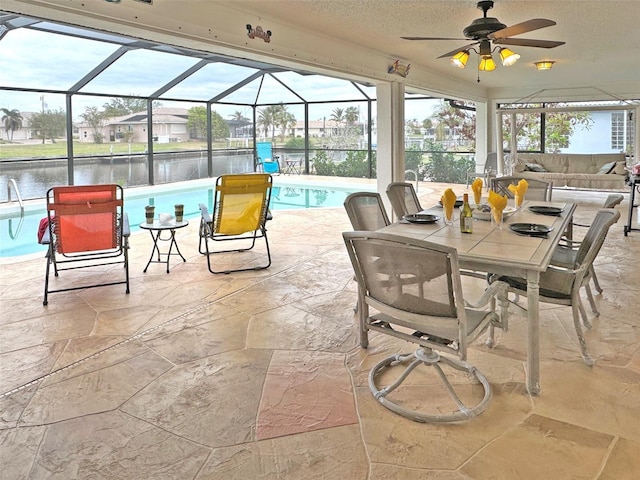 view of patio / terrace with glass enclosure, ceiling fan, and a water view