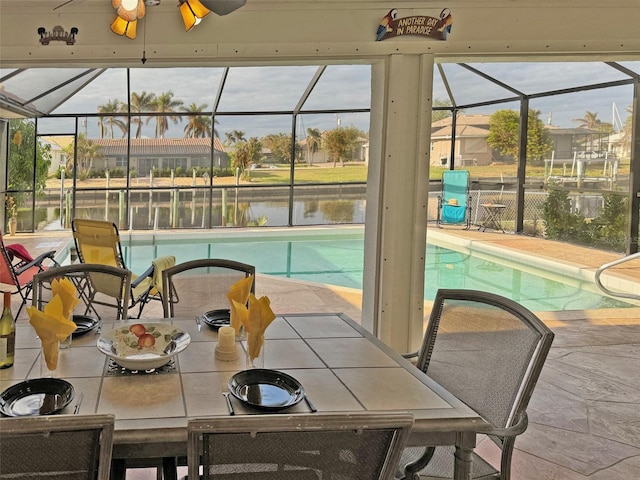 interior space with ceiling fan, a swimming pool, and a water view