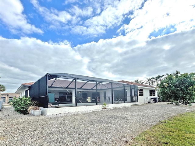 rear view of property featuring glass enclosure